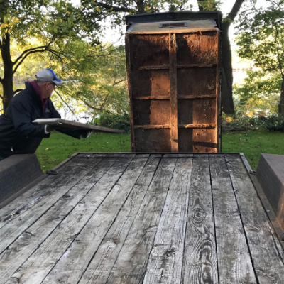 man loading small house on to trailer