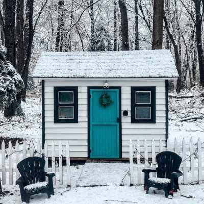 little white house with picket fence in the woods