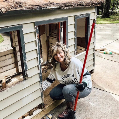 woman cleaning tiny house with broom