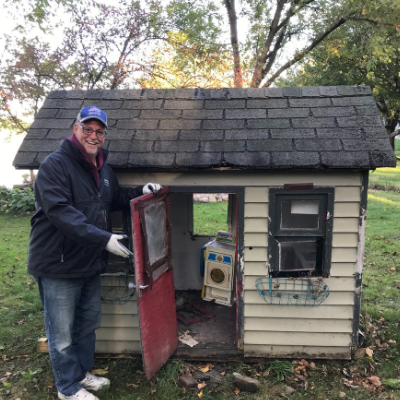 a man holding the door open to a tiny house