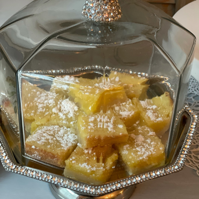 lemon bars in a glass cake plate