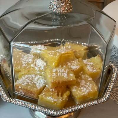 lemon bars in a fancy glass cake plate